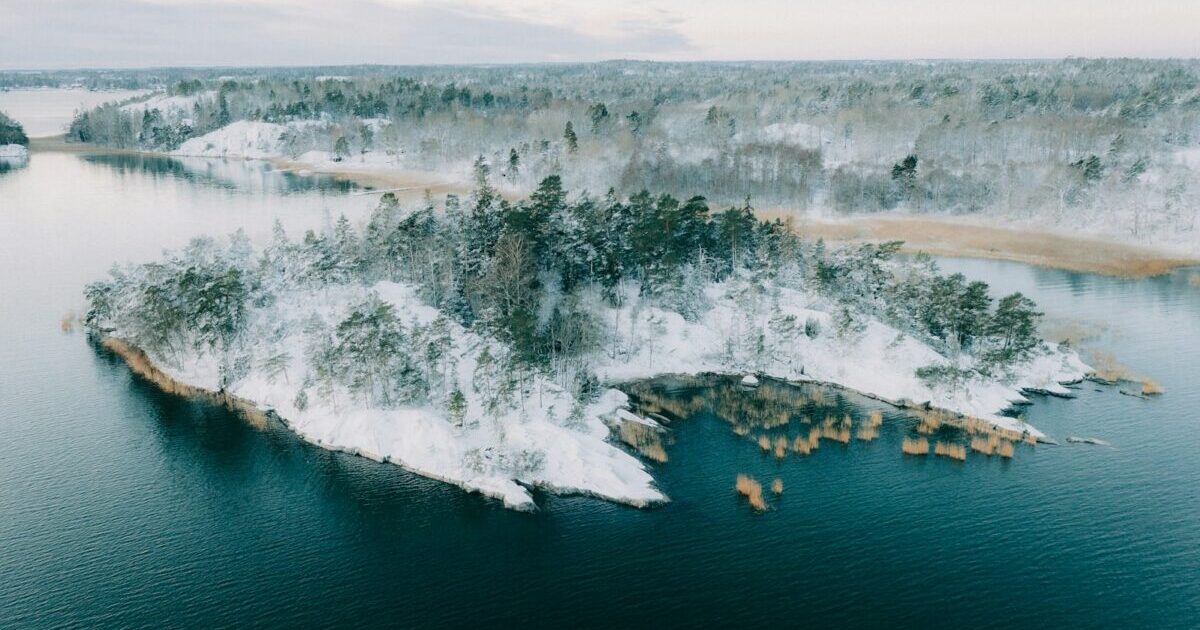 An island in the middle of a lake covered in snow