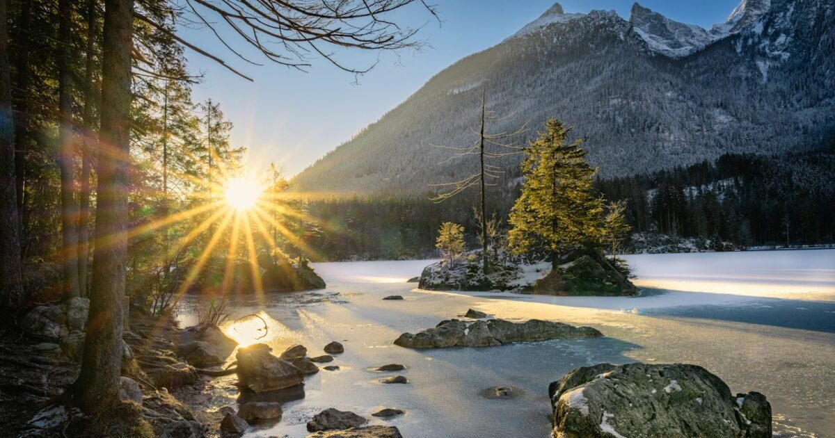 Sunrise illuminates a beautiful lake and snowy mountains.