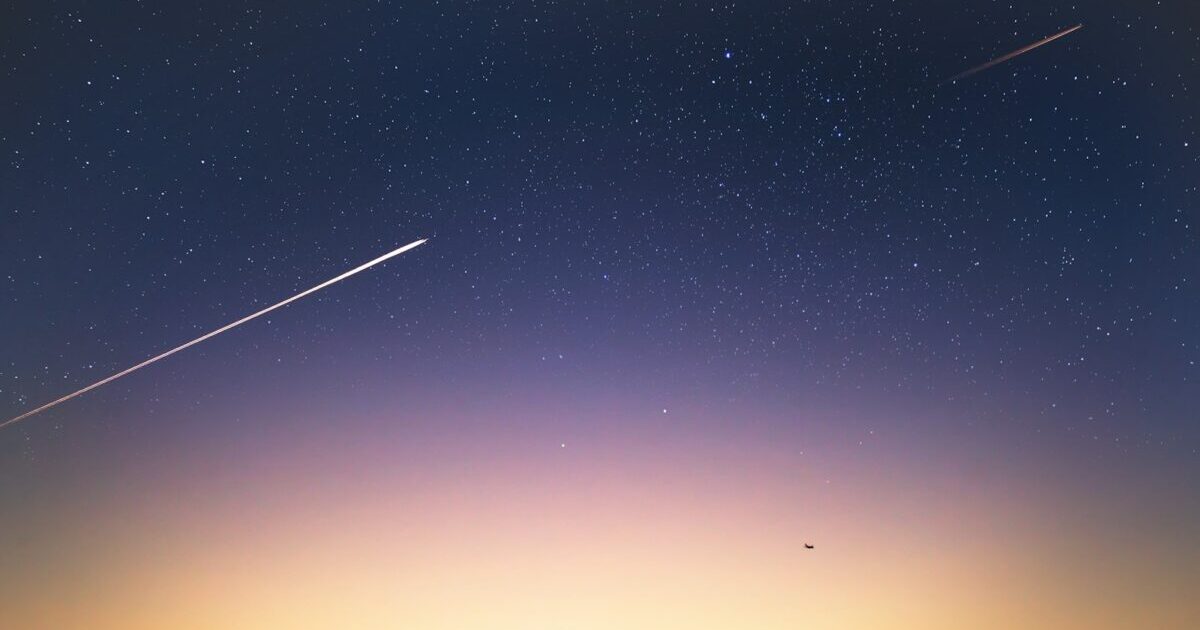 Starry night with shooting stars and a bright sunrise.